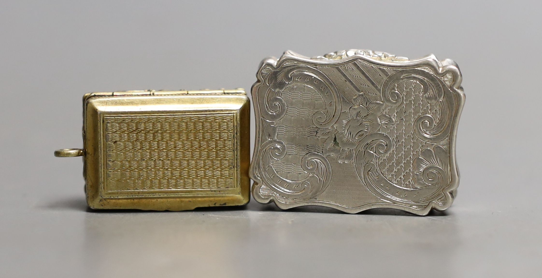 A George IV engine turned silver gilt vinaigrette, by Thomas Parker, Birmingham, with later bale,(date letter illegible), 30mm and a later vinaigrette by Nathaniel Mills, Birmingham, 1846, 36mm.